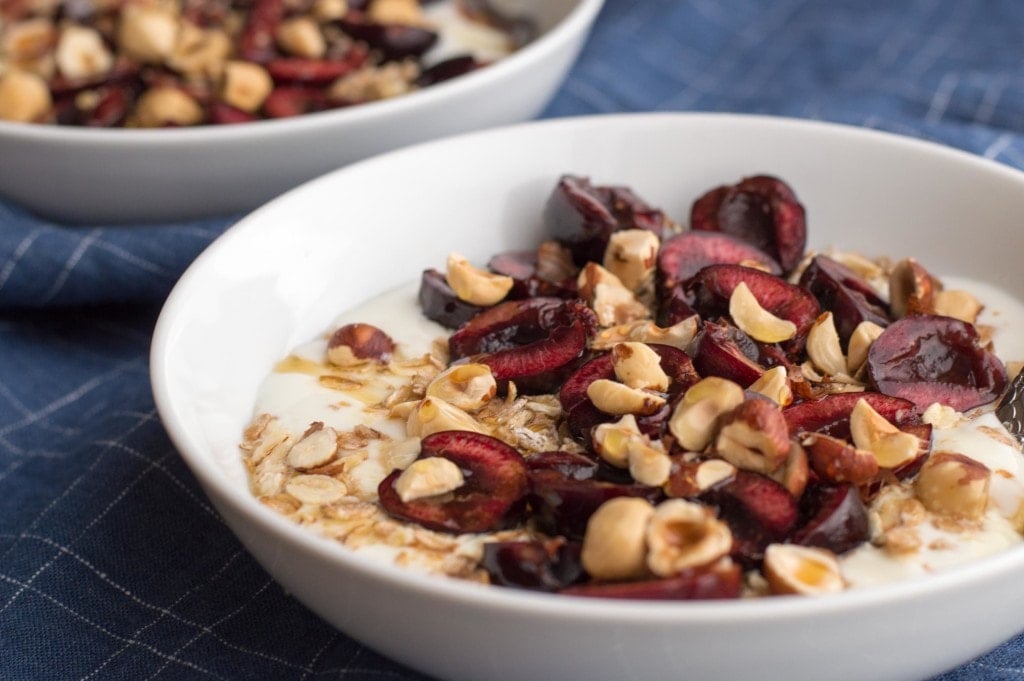 fresh cherry breakfast bowl with yogurt and hazelnuts